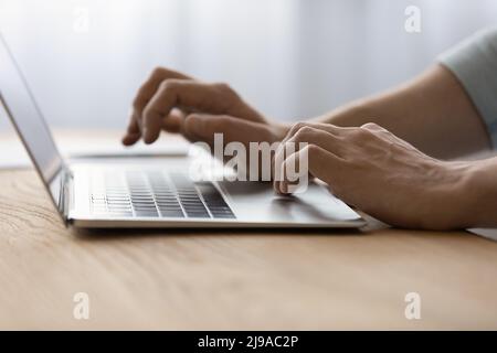 Closeup of young man hands typing on laptop computer keyboard Stock Photo