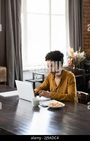 Serious African woman working or studying using laptop Stock Photo