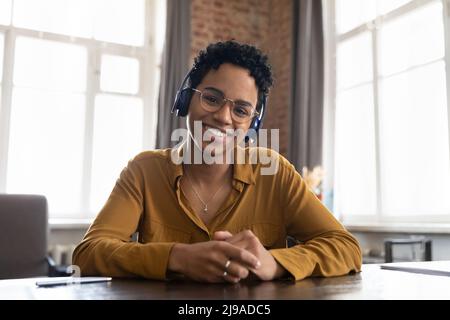 African woman looks at camera having virtual meeting through videoconference Stock Photo