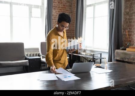 Serious African businesswoman sorting out papers working in modern office Stock Photo