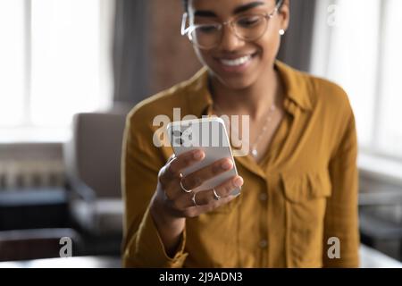 Close up cropped view African woman using smartphone Stock Photo
