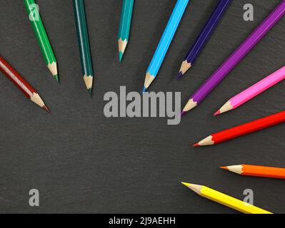 top view of colored pencils isolated on black slate background with copy space Stock Photo