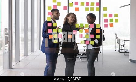 Leader of project explain to teammates information on sticky notes Stock Photo