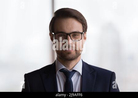 Headshot portrait handsome millennial businessman in formal suit posing indoor Stock Photo