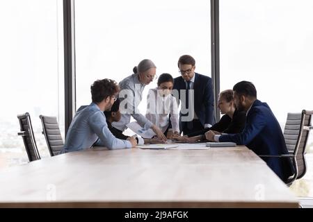 Team of diverse businesspeople discuss financial report at group meeting Stock Photo