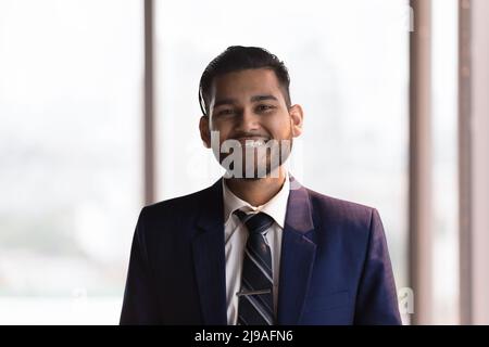 Smiling Indian businessman in elegant formal suit looking at camera Stock Photo