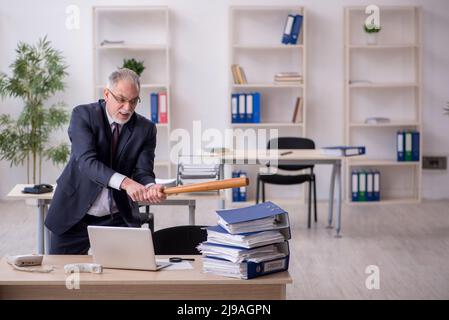 Old businessman employee unhappy with excessive work in the office Stock Photo