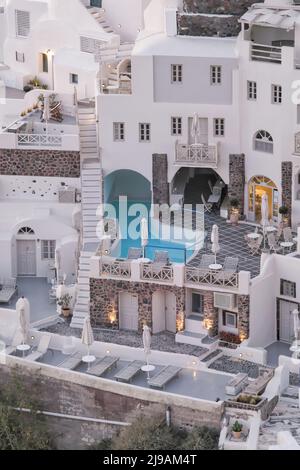 Oia, Greece - May 11, 2021 : Panoramic view of a stunning whitewashed hotel with swimming pools in Oia Santorini Stock Photo