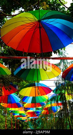 Rainbow umbrella on sky background. Many colorful umbrellas. umbrella street decoration Stock Photo
