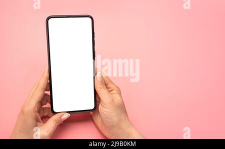 Woman hand using cellphone isolated on pink background. Female hands with cell phone. mobile phone blank white screen mockup. Shopping, delivery apps, Stock Photo