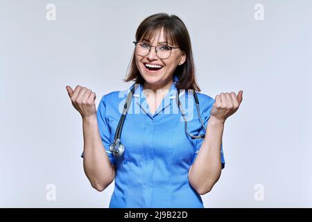 Happy nurse with emotion success joy victory, on a light studio background. Stock Photo