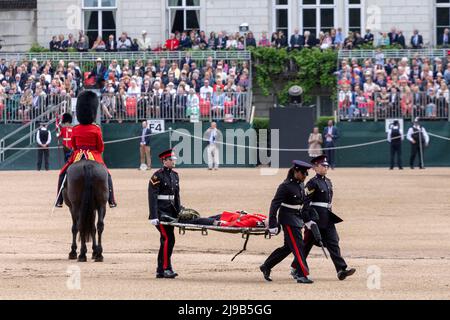 A member of the Irish Guards fainting under the high temperature today during the Major General’s review of Trooping the Colour at Horse Guards Parade Stock Photo
