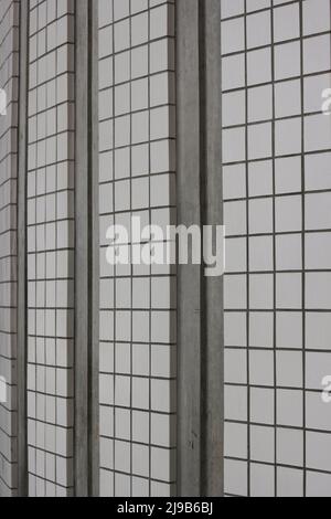 Square tiles on a wall in a grid repeat pattern in black and white. Stock Photo