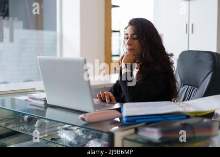 Thoughtful sports psychologist using netbook during work Stock Photo