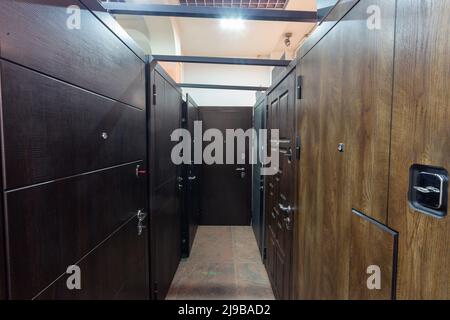 Entrance doors for sale in a specialized store. Buyers prefer metal doors, stylized as wooden. Stock Photo