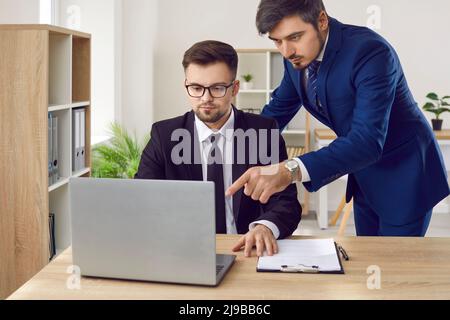 Serious lawyers are working on lawsuit using laptop and Internet to search for case data. Stock Photo