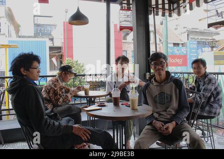 Yogyakarta, Indonesia - 08 07 2019: happy expressions of men sitting together enjoying a cup of coffee Stock Photo