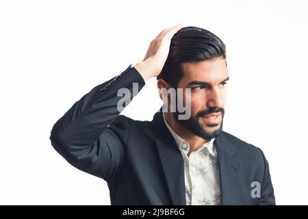 young attractive bearded businessman fixing his hair and looking at the side. High quality photo Stock Photo