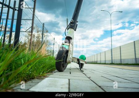 Single electric scooter stands on the pavement next to the street Stock Photo