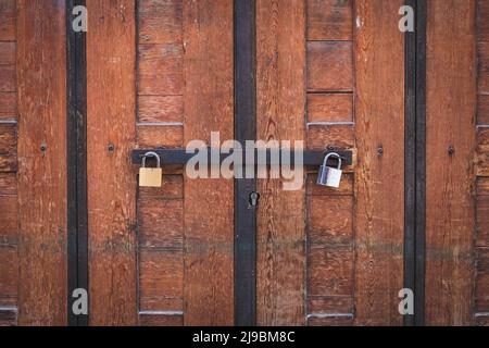 two padlocks on wooden door, closed gate Stock Photo