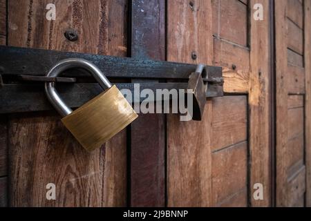 padlock closeup on vintage, wooden door or closed gate Stock Photo