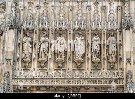 Religious statues and grotesques above the main entrance porch of the south facade of Gloucester Cathedral, Gloucestershire, England, United Kingdom. Stock Photo