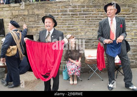 Haworth, West Yorkshire, UK. 22nd May, 2022. Spivs try to interest passers by in their wares at at Haworth 1940s weekend. Haworth 1940s weekend is an annual event celebrating the 1940s. Credit: Paul Thompson/Alamy Live News Stock Photo