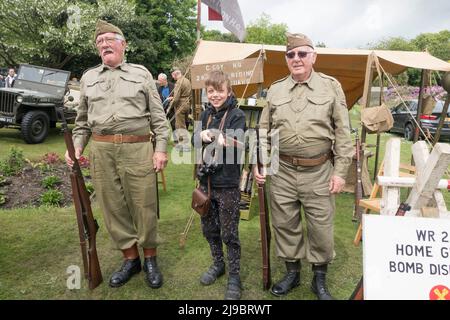 Haworth, West Yorkshire, UK. 22nd May, 2022. Two men dressed as Home Gaurd volunteers instruct a young boy in rifle use at Haworth 1940s weekend. Haworth 1940s weekend is an annual event celebrating the 1940s. Credit: Paul Thompson/Alamy Live News Stock Photo