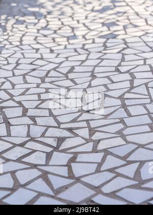 Pattern of broken white tiles, brittle, mosaic, trencadis breakable, enamelled ceramics glazed, perspective view with light reflections Stock Photo