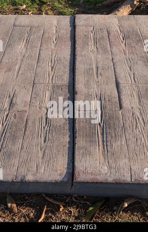 Separation and breakage between pavement sections. Expansion joint working at stamped concrete pavement, Wooden slats pattern, flooring exterior Stock Photo