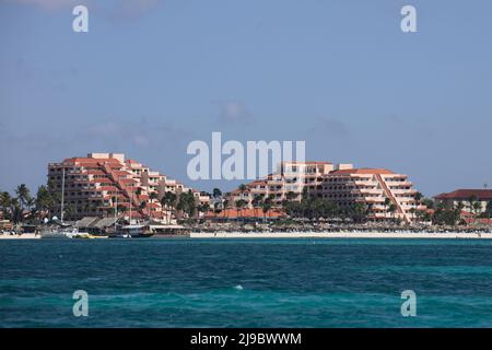 PALM BEACH, ARUBA - OCTOBER 17, 2021: View from the sea of the Playa Linda Beach Resort along Palm Beach with tour boats at pier on Aruba Stock Photo