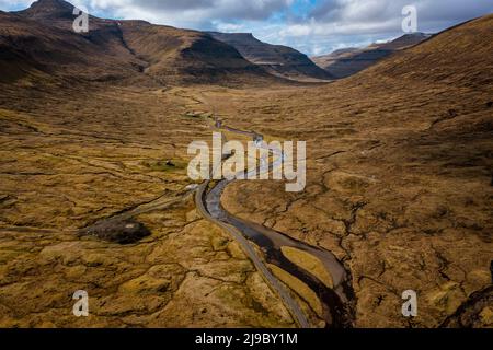 A scenic long road in a valley in Saksun on the Faroe Islands. Stock Photo