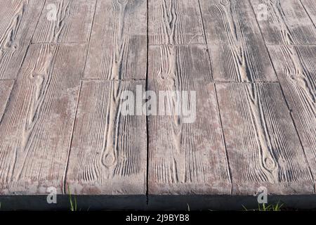 stamped concrete pavement expansion joint at middle, Wooden slats pattern, flooring exterior, decorative texture of cement paving with streaks of wood Stock Photo