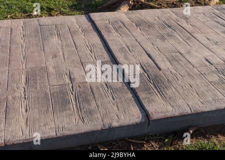 stamped concrete pavement outdoor with expansion joint working, Wooden slats pattern, flooring exterior, decorative cement paving with streaks Stock Photo