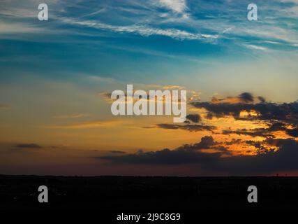 Evening sky. The rays of the sun break through the clouds above the horizon. Abstract background. Stock Photo