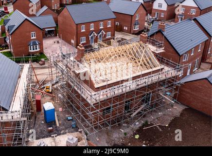 An aerial view of new build homes on a new housing estate with the roof exposed and wooden rafters and beams showing Stock Photo