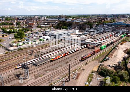 An aerial landscape view of passenger and freight trains waiting on the platforms of Peterborough train station on the East Coast Main Line railway Stock Photo