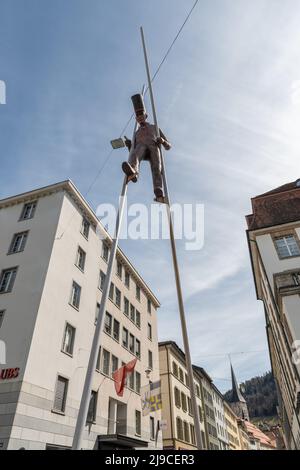 Chur, Switzerland, April 11, 2022 Sculpture of a man walking on stilts in the city center Stock Photo