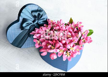 Heart shape gift box and bouquet. Flowers a gift in the shape of a heart. Flowers in a box heart on white background. Holiday concept. Stock Photo