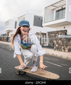 Real skater young woman skating, smiling, having fun Stock Photo