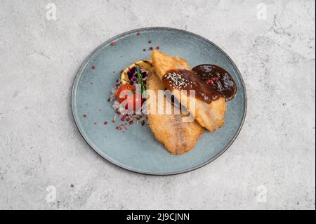 Fried tilapia fish with rice sauce and vegetable. Stock Photo