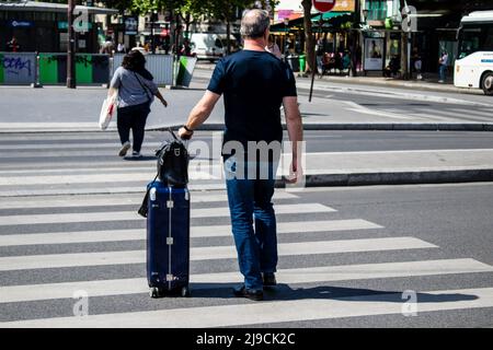 Paris, France - May 21, 2022 Tourists walking in the streets of Paris near the train station during the coronavirus outbreak hitting France, wearing a Stock Photo