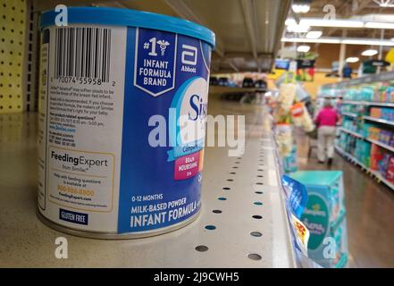 A woman pushes a shopping cart down an aisle past a single can of Similac Advance with iron powdered infant formula sitting on an otherwise empty shelf on Saturday, May 21, 2022 at a Kroger store in Owensboro, Daviess County, KY, USA. A combination of ongoing supply chain problems, voluntary product recalls and reported panic buying by consumers has resulted in widespread scarcity of infant formula in the United States. (Apex MediaWire Photo by Billy Suratt) Stock Photo