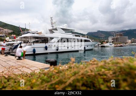 Budva, Montenegro - August 26, 2021: Luxury yacht anchored at harbour in the town of Budva, Montenegro. Luxury travel destination with beatuiful beach Stock Photo