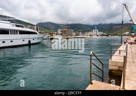 Budva, Montenegro - August 26, 2021: Luxury yacht anchored at harbour in the town of Budva, Montenegro. Luxury travel destination with beatuiful beach Stock Photo