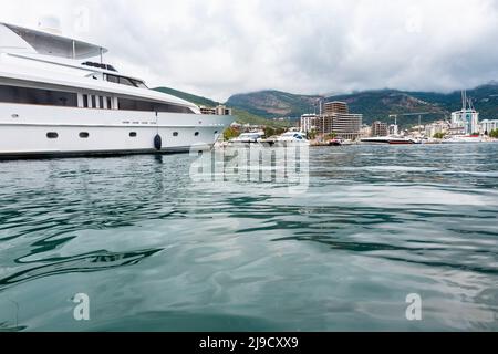 Budva, Montenegro - August 26, 2021: Luxury yacht anchored at harbour in the town of Budva, Montenegro. Luxury travel destination with beatuiful beach Stock Photo