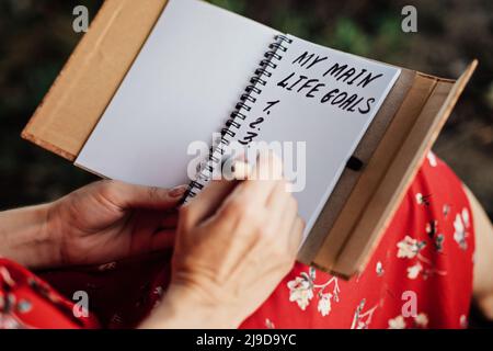 Main life goals, How to Set and Achieve Life Goals. Female hands write in a notebook the inscription My life goals Stock Photo
