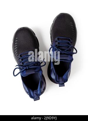 Pair of new laced up sneakers isolated on white background. Textile mesh shoes with laced fastening cutout. Black blue sneakers for active lifestyle. Stock Photo
