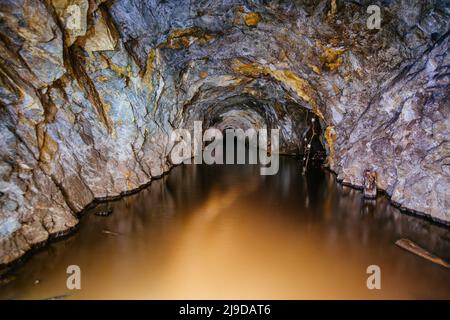 Dark flooded abandoned mine tunnel. Stock Photo