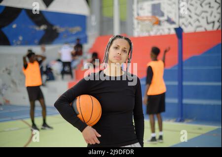 Self assured black female basketball player on sports ground Stock Photo
